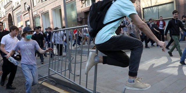 A protester jumps over a police barrier during a demonstration against President Vladimir Putin in Pushkin Square as Russians angered by the impending inauguration of Vladimir Putin to a new term as the country's president demonstrated throughout the country on Saturday.