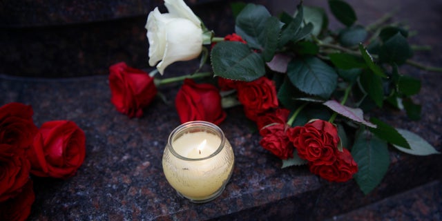 Flowers and candles are placed at the choir's building in Moscow, Russia.