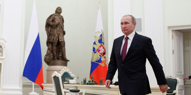 Russian President Vladimir Putin walks to meet with Moldovan President Igor Dodon in Moscow's, Kremlin, Russia, Tuesday, Jan. 17, 2017. Dodson is in Russia on an official visit. (Sergei Ilnitsky/Pool photo via AP)