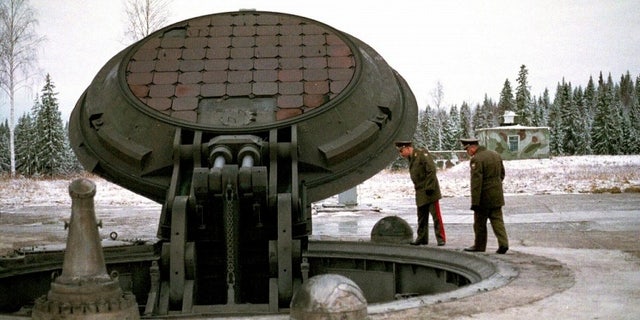 Russian high ranking military officials look into an opened silo of a Russian intercontinental ballistic Topol-M missile.