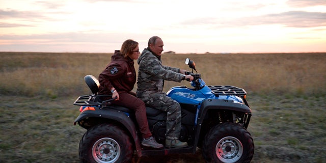 Russian President Vladimir Putin rides a quad bike as he visits a reserve for wild horses near the Urals city of Orenburg, about 800 miles southeast of Moscow, Russia, Monday, Oct. 3, 2016.