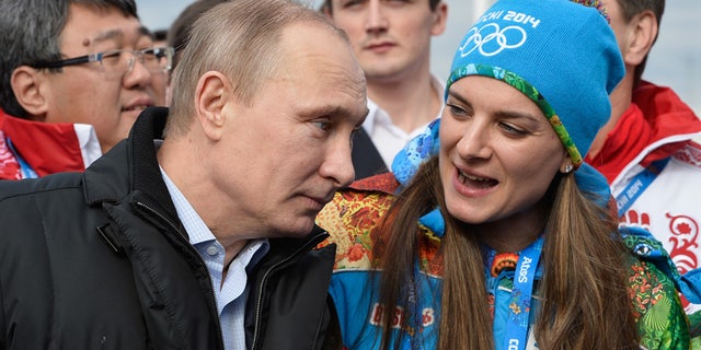 In this Feb. 5, 2014 file photo Russian President Vladimir Putin speaks with Olympic Village Mayor Elena Isinbaeva while visiting the Coastal Cluster Olympic Village ahead of the Sochi 2014 Winter Olympics in Sochi, Russia.