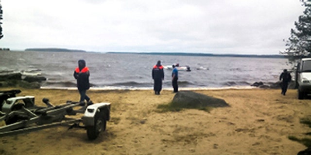 Russian Ministry for Emergency Situations workers stand at the site of an incident at a lake in the Karelia region.