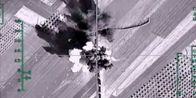 In this photo made from the footage taken from Russian Defense Ministry official web site on Monday, Feb. 1, 2016, an aerial image shows what it says is a column of heavy trucks carrying ammunition hit by a Russian air strike near Aleppo, Syria.