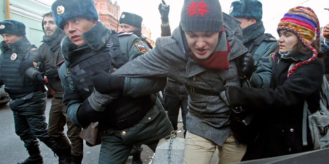 Dec. 19, 2012: In this Wednesday file photo police officers detain gay right activists during a protest near the State Duma, Russia's lower house of parliament, in Moscow, Russia.