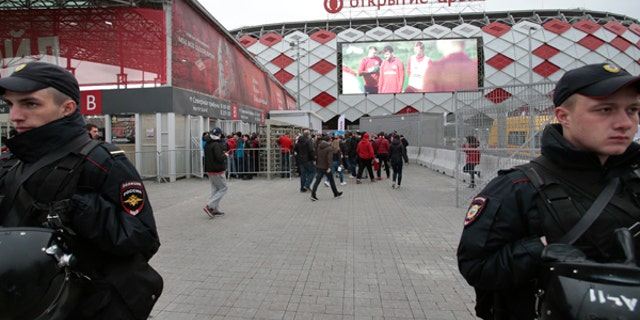 In this Wednesday, May 17, 2017 photo Russian police officers guard as fans arrive for a soccer match at Otkrytie Arena, stadium of Spartak Moscow soccer club, where Confederations Cup matches will be played, in Moscow, Russia. Terrorists, hooligans and anti-corruption protesters are among the main concerns for the Russian security forces during the Confederations Cup soccer tournament running from Saturday June 17 until Sunday July 2. (AP Photo/Ivan Sekretarev)