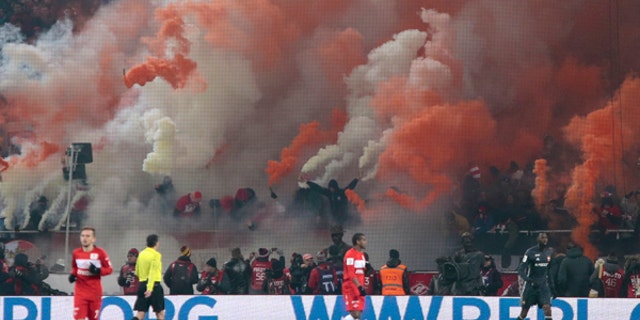 FILE - In this Saturday, Oct. 29, 2016 filer, Spartak fans fire flares and other pyrotechnics during the national championship soccer match between Spartak and CSKA in Moscow. Russian President Vladimir Putin has imposed a package of security measures, but faces criticism from observers who say his order could hamper ordinary Russians' lives and stifle protests. The June 17-July 2 Confederations Cup has four host cities and next year's World Cup will have 11. (AP Photo/Ivan Sekretarev, File)