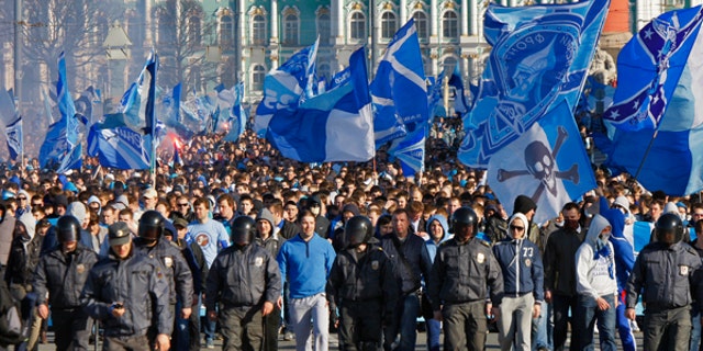 FILE - In this Saturday, April 28, 2012 file photo Zenit's fans march prior the match of their team in the national soccer Championship in downtown St.Petersburg, Russia. A new report seen by the Associated Press shows Russia has made progress fighting football racism ahead of the Confederations Cup and next year's World Cup, but warns that anti-Semitism in stadiums has grown and that racist fans are using far-right codes to smuggle offensive messages into stadiums. (AP Photo/Dmitry Lovetsky, file)