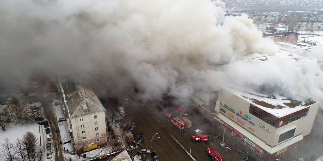 In this Russian Emergency Situations Ministry photo, on Sunday, March 25, 2018, smoke rises above a multi-story shopping center in the Siberian city of Kemerovo.