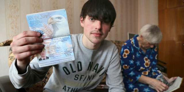 March 20, 2013: Alexander Abnosov shows his American passport to journalists in the Volga river city of Cheboksary, Russia.