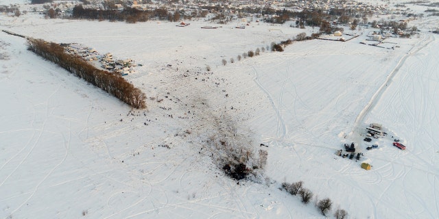 Emergency workers explore the site of a AN-148 plane crash on Monday.