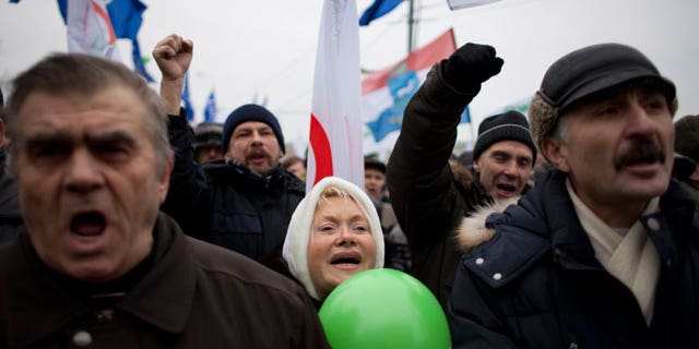 Dec. 17, 2011: With Yabloko party flags in the background, Russian protesters shout slogans during a rally to protest against alleged vote rigging at Bolotnaya Square, on an island in the Moscow River adjacent to the Kremlin in Moscow, Russia.