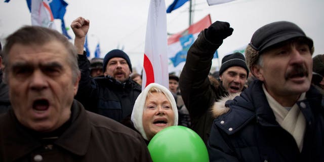 Dec. 17, 2011: With Yabloko party flags in the background, Russian protesters shout slogans during a rally to protest against alleged vote rigging at Bolotnaya Square, on an island in the Moscow River adjacent to the Kremlin in Moscow, Russia.
