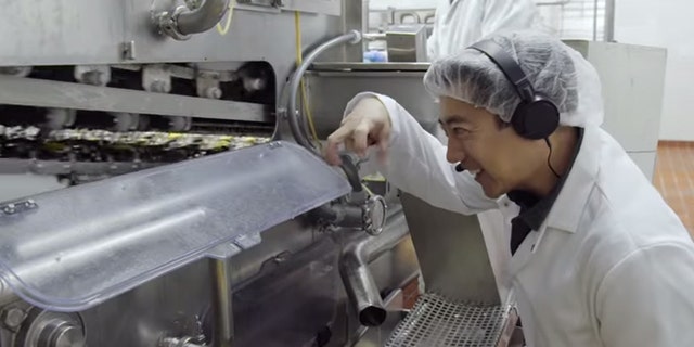 Grant Imahara inspects the egg-breaking machine.