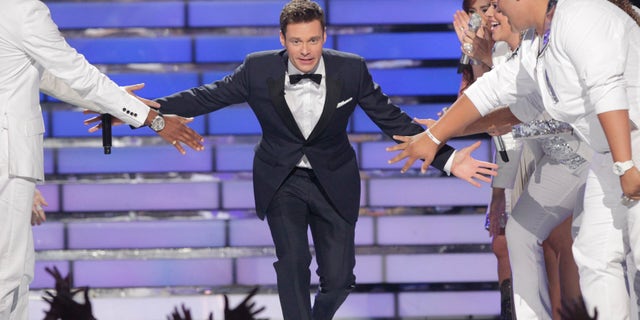 Host Ryan Seacrest arrives on the stage during the 11th season finale of "American Idol" in Los Angeles, California, May 23, 2012. REUTERS/Mario Anzuoni (UNITED STATES - Tags: ENTERTAINMENT) - RTR32JHI