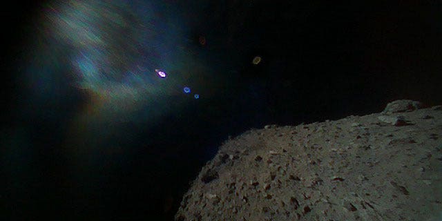 Image captured by Rover-1B on Sept. 21. This color image was taken immediately after separation from the spacecraft. The surface of Ryugu is in the lower right. The coloured blur in the top left is due to the reflection of sunlight when the image was taken. (Image credit: JAXA)
