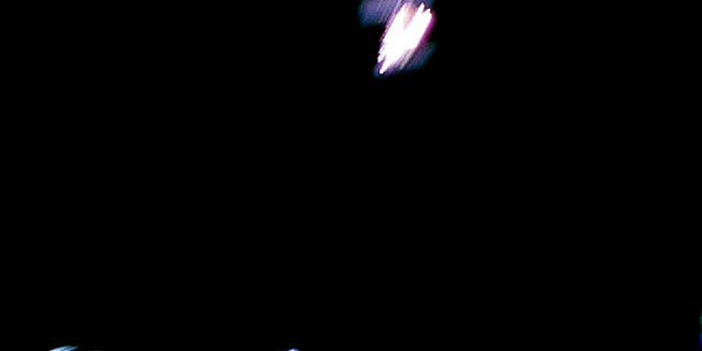 Image captured by Rover-1A on Sept. 21. This is a color image taken immediately after separation from the spacecraft. Hayabusa2 is at the top and the surface of Ryugu is bottom. The image is blurred because the shot was taken while the rover was rotating. (Image credit: JAXA)
