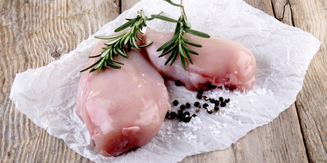 chicken fillet with rosemary, salt and pepper on white kitchen paper