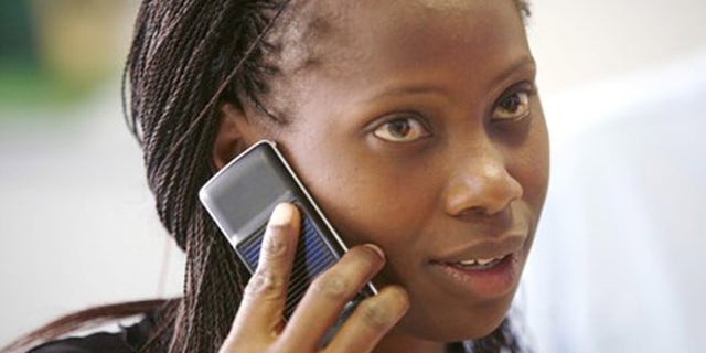 A Safaricom client uses a solar-charged mobile phone handset at a retail centre in Kenya's capital Nairobi, in this September 22, 2009 file photo. Solar cellphones could build on the economic advantages that mobile phones have already brought to far-flung regions of Africa and the Indian subcontinent, including price transparency and more accurate and timely information. Mobile phone penetration in these regions has been held back by a lack of electricity: there is simply no way to charge a cellphone in many rural areas of developing countries. To match feature CELLPHONES-SOLAR/. REUTERS/Thomas Mukoya/Files (KENYA BUSINESS SCI TECH)