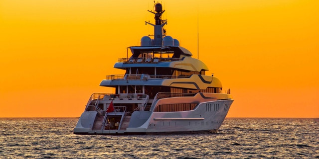 Luxury yacht on open sea at golden sunset
