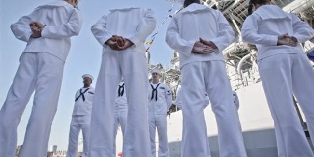 U.S. sailors of the USS Monterey stand next to their vessel in the Black Sea port of Constanta, Romania, Tuesday, June 7, 2011.