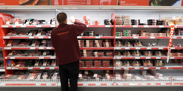 A Sainsbury's worker stacks a meat shelf in a store in Redhill, Britain, March 27, 2018.