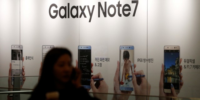 A woman talking on her mobile phone walks past an advertisement promoting Samsung Electronics' Galaxy Note 7 at company's headquarters in Seoul, South Korea, October 11, 2016. (REUTERS/Kim Hong-Ji)