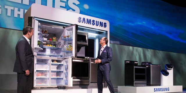 John Herrington (L), senior vice president of Samsung Electronics America, and Tim Baxter, president of Samsung Electronics America, pose by Samsung Chef Collection kitchen appliances at a Samsung Electronics news conference during the 2015 International Consumer Electronics Show (CES) in Las Vegas, Nevada Jan. 5, 2015. (REUTERS/Steve Marcus)