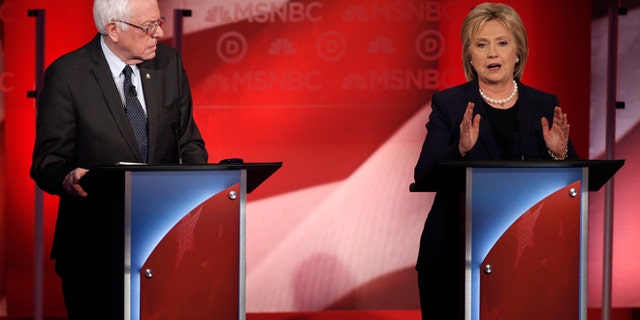 Democratic U.S. presidential candidate Senator Bernie Sanders (L) listens to former Secretary of State Hillary Clinton speak during the Democratic presidential candidates debate sponsored by MSNBC at the University of New Hampshire in Durham, New Hampshire, February 4, 2016. REUTERS/Mike Segar - RTX25IQ6