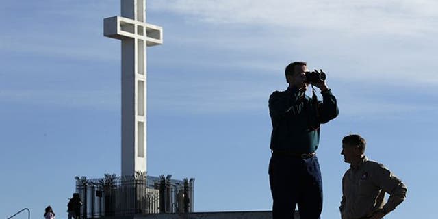 FILE: Jan. 4, 2011: Rev. John Fredericksen of Orlando, Fla., takes a picture in front of the war memorial cross on Mount Soledad in San Diego, alongside Burdette Streeter of San Diego.