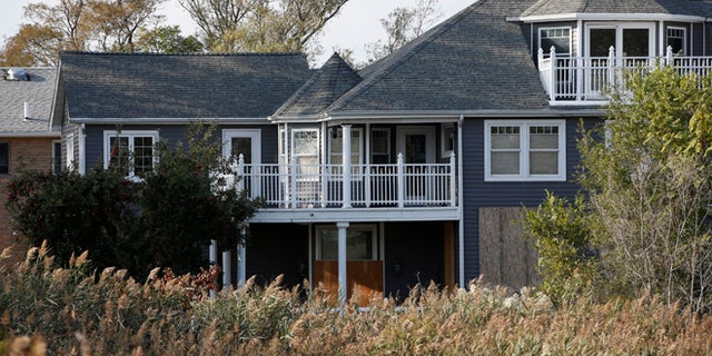 Oct. 2, 2013: This photo shows Joe Monte's abandoned Oakwood Beach dream house, boarded-up behind overgrown invasive phragmite plants, in the Staten Island borough of New York. Monte has hardly set foot in the house he spent 20 years building since Superstorm Sandy breached nearby sand dunes, flooding the area and severely damaging the property. Monte is among over 400 homeowners that will receive buyouts from the state so they can relocate and rebuild in less vulnerable vulnerable areas.