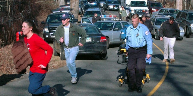 Dec. 14, 2012: In this file photo provided by the Newtown Bee, paramedics and others rush toward Sandy Hook Elementary School in Newtown, Conn., shortly after Adam Lanza opened fire, killing 26 people, including 20 children.
