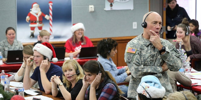 NORAD and US Northern Command Chief of Staff Maj. Gen. Charles D. Luckey joins volunteers taking calls from children about Santa's whereabouts.