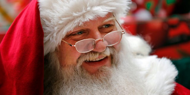 A man representing Santa Claus sits in a mall in South Portland, Maine.