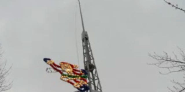 A Santa has displaced a flag on a flagpole in Willoughby, Ohio.