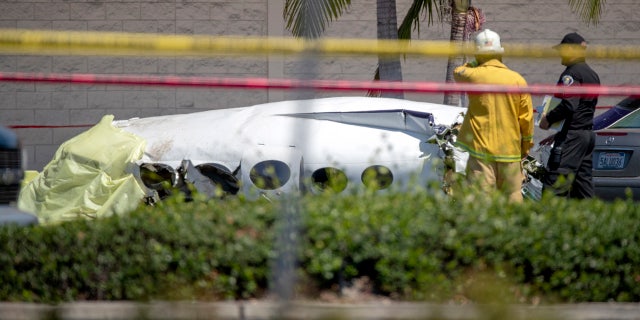 Santa Ana fire and police and Orange County Fire departments respond to the scene of a deadly plane crash in a parking lot.