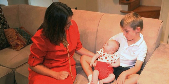 In this frame grab from video, taken Sept. 14, 2016, Sarah Gray with her son Callum, 6, and infant daughter Jocelyn in their Washington home. Callum's identical twin Thomas died of a birth defect when he was just 6 days old, and the family donated Thomas' eyes, liver and umbilical cord blood for medical research. Now Gray has written a book about her unusual journey to find out if that donation really made a difference, revealing a side of science laymen seldom glimpse.