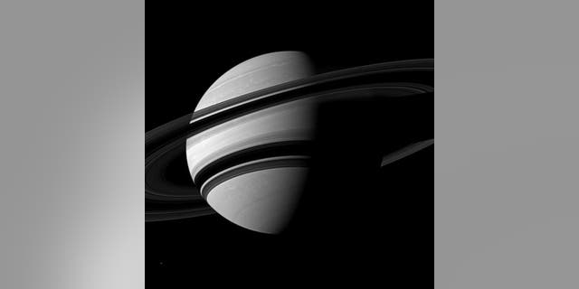 NASA's Cassini spacecraft snapped this angled shot of Saturn, showing the southern reaches of the planet with the rings on a dramatic diagonal. Saturn's icy moon Enceladus is visible as a tiny white speck in the lower lefthand corner. The pictu