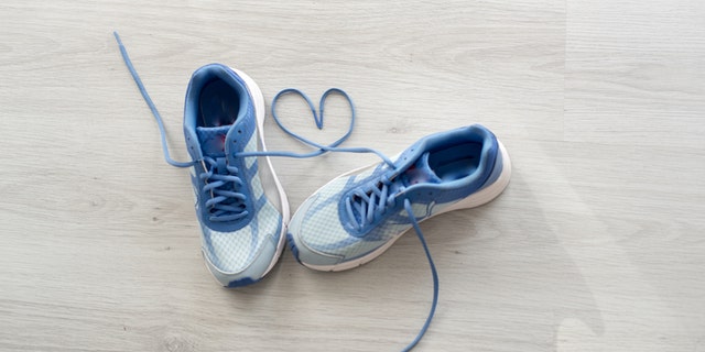 Love sign, Selective focus close up blue sport shoes on gray floor.