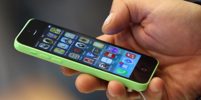 BERLIN, GERMANY - SEPTEMBER 20: A customer tries out the new Apple iPhone 5C smartphone at the Berlin Apple Store on the first day of sales on September 20, 2013 in Berlin, Germany. The new iPhone 5S and 5C phones went on sale all over the world today and hundreds of customers waited outside the Berlin store in the rain to be among the first to buy the new phones starting at 8am. (Photo by Sean Gallup/Getty Images)