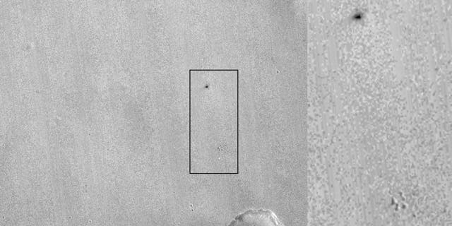 This image by NASA's Mars Reconnaissance Orbiter shows what appears to be the ExoMars lander's parachute (bright spot at bottom) and the impact site of the lander itself (dark patch at top).
