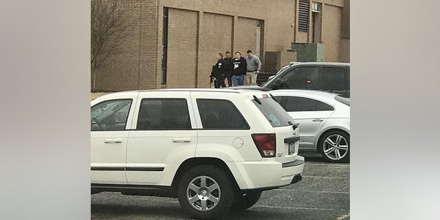 Police escort a person from the school. It was not immediately clear if the boy was the gunman.