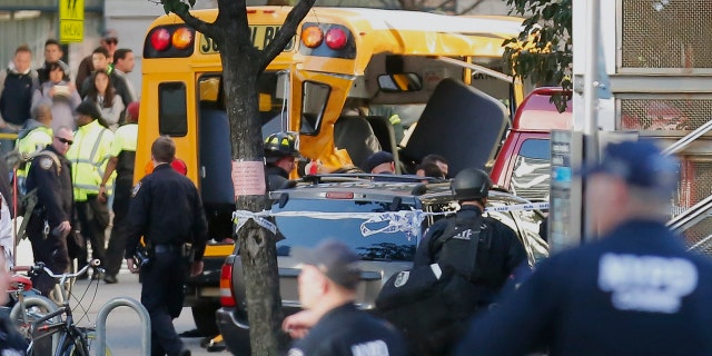 Authorities respond near a damaged school bus Tuesday, Oct. 31, 2017, in New York. A motorist drove onto a busy bicycle path near the World Trade Center memorial and struck several people on Tuesday police and witnesses said. (AP Photo/Bebeto Matthews)