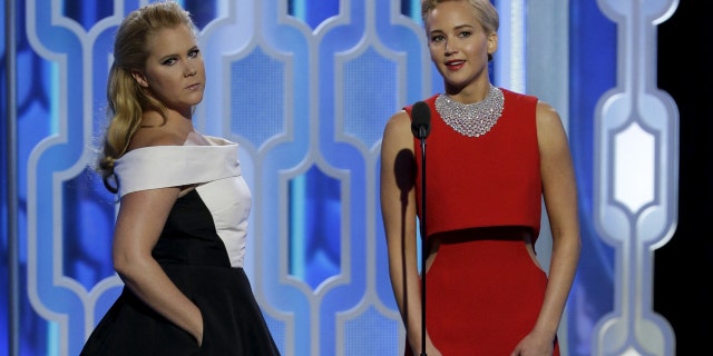 Amy Schumer (L) and Jennifer Lawrence presenting at the 73rd Golden Globe Awards in Beverly Hills, California January 10, 2016.