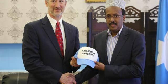Stephen Schwartz, the U.S. ambassador in Somalia, giving the Somali president a "Make Somalia Great Again" hat.