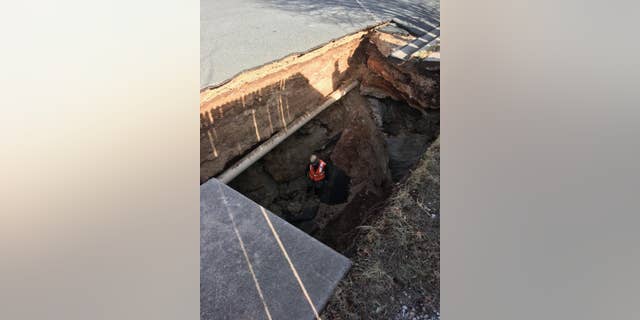 A scientist explores the cave entrance , which is about 20-22 feet high.