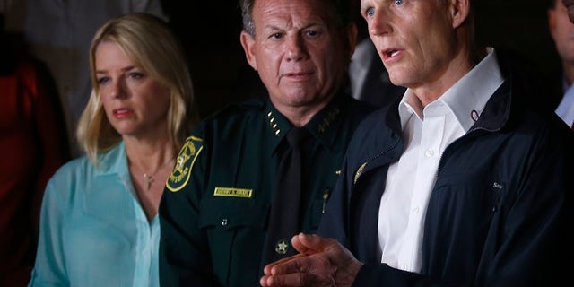Florida Gov. Rick Scott, right, said the police response to the Parkland high school shooting will be investigated. Dozens of lawmakers are demanding Scott suspend Israel.