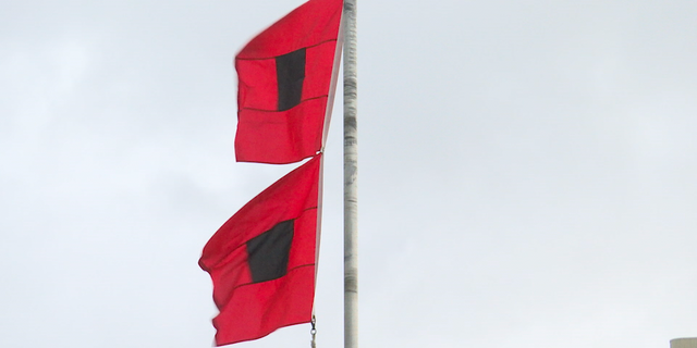 Gulf waters are closed to swimmers with double red flags flying, signaling life-threatening rip currents and surf conditions.