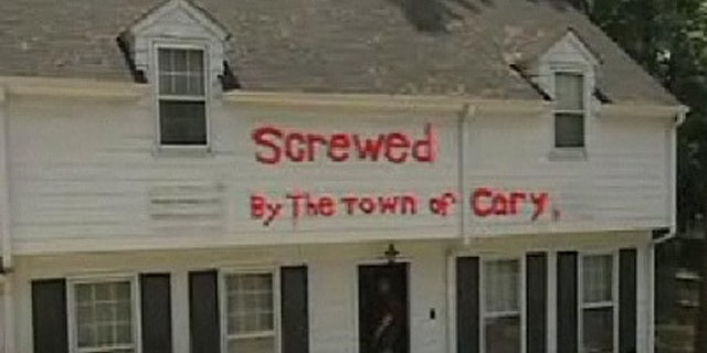 In 2009, David Bowden sued when town officials tried to fine him for a sign in his yard that read "Screwed by the town of Cary" painted in neon orange. Bowden claims his home was damaged by runoff that he blames on local road construction. (MyFox8.com)