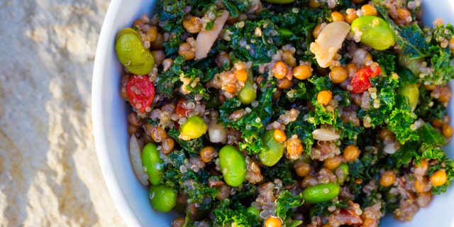 Raw paleo quinoa kale salad in a bowl. Healthy eating diet food.
